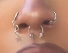 a woman's nose is shown with silver hoop earrings