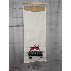 a white towel hanging on a wooden wall with an image of two dogs in a wagon