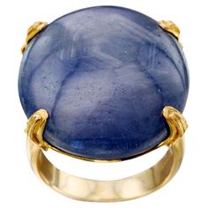 A large, 22 x 28 mm, oval cabochon blue sapphire showing an interesting hexagonal pattern which demonstrates the crystalline lattice structure of the sapphire gem provides a magical centerpiece in this 18K gold ring design. The stone is held simply by 4 sculptured prongs decorated with spiral wire accents atop a matte-finish tapered band. This ring is currently sized 7.5, resizable by your local jeweler. It's rare to find such an impressively sized blue sapphire with these natural markings. A substantial and one of a kind piece! Luxury Round Cabochon Sapphire Ring, Luxury Classic Ring-shaped Cabochons, Luxury Sapphire Ring With Cabochon, Luxury Antique Cabochon Sapphire Ring, Luxury Vintage Sapphire Cabochon Ring, Gold Ring Design, Lattice Structure, Hexagonal Pattern, Sapphire Gem