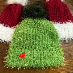 three knitted christmas hats sitting on top of a wooden table