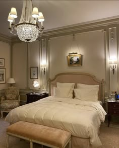 a bedroom with a chandelier hanging from the ceiling and a bed in it