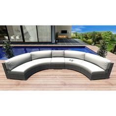 an outdoor sectional sofa sitting on top of a wooden deck next to a swimming pool