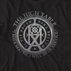 John Wick High Table Coin T-Shirt "Show off your allegiance to the High Table with our John Wick High Table Coin T-Shirt. This stylish shirt features the iconic coin from the John Wick franchise, making it a must-have for any fan. Comfortable and eye-catching, this shirt is perfect for any occasion. Join the High Table today! Officially Licensed 100% Cotton Short Sleeves Color: Black Printed in the U.S.A. with eco-friendly inks Machine Washable Listed in adult unisex sizes ** This product ships The High Table John Wick, John Wick High Table, John Wick Coins, Survival Cache, Bike Stickers, Stickers Design, Table Service, Shirts Ideas