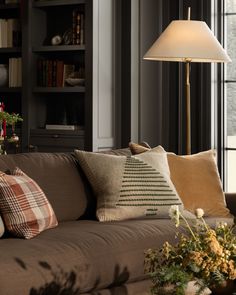 a living room filled with lots of furniture and a lamp on top of a table