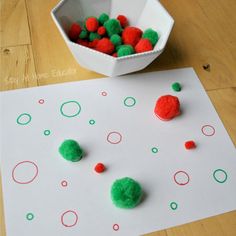 a paper plate with pom poms on it next to a bowl of balls