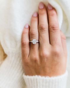 a woman's hand with a diamond ring on it