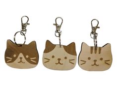 three wooden key chains with cats on them