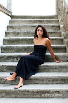 a woman is sitting on the steps outside