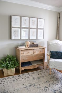 a living room with a rug, chair and pictures on the wall above it's dresser