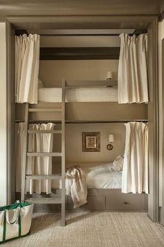 there is a bunk bed with curtains on the top and bottom, next to a ladder