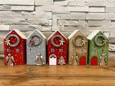 five small wooden houses with christmas decorations on them