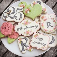 decorated cookies are arranged on a plate with the date 25th, anniversary and 25 years