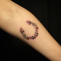 a woman's arm with flowers and leaves on it