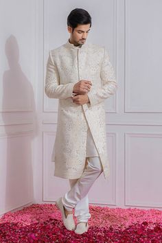 Off white sherwani with sequin and floral embroidery, mandarin collar and full sleeves. 
Component: 1
Pattern: Embroidered
Type Of Work: Sequin
Neckline: Mandarin
Sleeve Type: Full Sleeves
Fabric: Pure Georgette, Cotton Silk
Color: White
Other Details: 
Sequin work
Note: Churidar and inner kurta worn by the model is not for sale
Occasion: Groom,Wedding - Aza Fashions Naqshi Embroidered Straight Sherwani For Reception, Naqshi Embroidered Straight Kurta Sherwani For Reception, Naqshi Embroidered Sherwani For Reception, Naqshi Embellished Sherwani For Eid Reception, Eid Sherwani With Naqshi For Reception, Off White Unstitched Bandhgala With Long Sleeves, Eid Reception Sherwani With Naqshi, Unstitched Off White Bandhgala With Long Sleeves, White Straight Kurta Bandhgala For Wedding