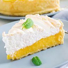 a slice of lemon meringue pie with whipped cream and mint leaves on top