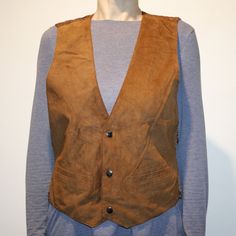 "Vintage cognac brown suede leather men`s vest. M size. Unisex Waistcoat. Boho western vest. Made in India. Unisex Waistcoat, western button up suede front waistcoat. Textile (polyester) lining and back. 2 sides pockets. Sewn up belt on the back. Dry cleaning only.  labeled materials of shell: genuine leather, lining 100% polyester labeled size: M Measurements (in lying flat): Length from front:  61 cm / 24\" in armpit to armpit: 50 cm / 19.5\" in Please check measurements to insure a proper fit. Remember to allow yourself some extra room for movement. You can compare these with something from your closet that fits you well. Condition: used a little bit, but without damages. #IB120" Western Leather Vest For Fall, Brown Sleeveless Vest For Western-themed Events, Western Style Vest With Pockets For Fall, Western Style Brown Vest For Western-themed Events, Brown Western Vest For Western-themed Events, Fitted Western Style Winter Vest, Fitted Western Vest For Winter, Fitted Western Style Outerwear Vest, Fitted Western Style Vest Outerwear