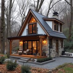 a small house in the woods with lots of windows and lights on it's roof