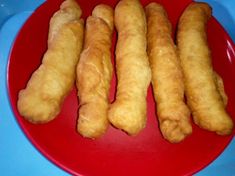 four pieces of fried food on a red plate