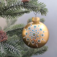 a gold ornament hanging from a christmas tree