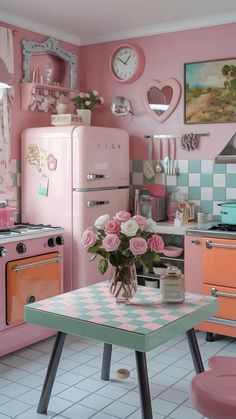 a kitchen with pink appliances and flowers on the table