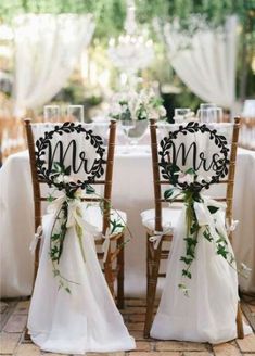 two chairs with mr and mrs signs on them are set up for a wedding reception