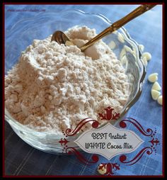 a glass bowl filled with white chocolate and marshmallows next to a spoon