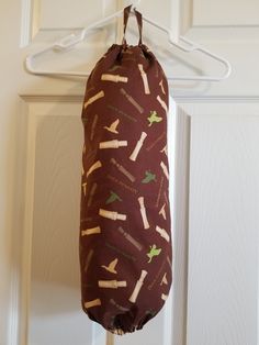 a brown bag hanging from a hook on a white door with wine corks all over it