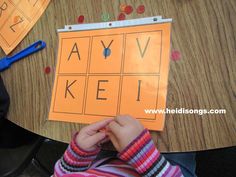 a young child is doing an activity with letters on the paper that spell out aav keli