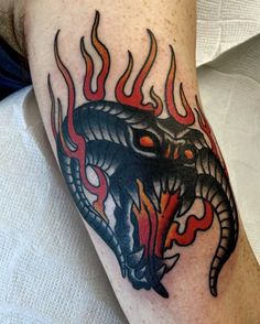 a man with a tattoo on his arm and an image of a snake in flames