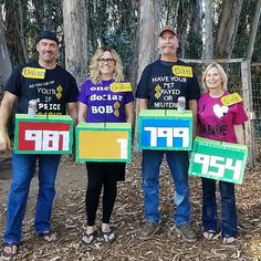 four people holding up signs in front of trees