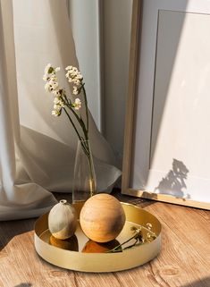 two vases with flowers in them sitting on a wooden table next to a window