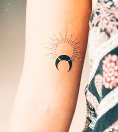 a woman's arm with a sun and moon tattoo on the left side of her arm