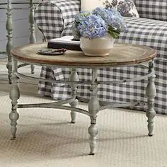 a living room filled with furniture and flowers on top of a coffee table in front of a couch