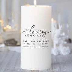 a white candle with the words in loving memory on it