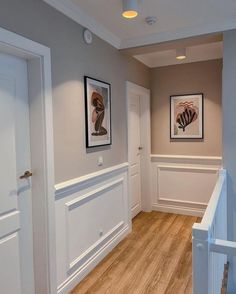 an empty hallway with white walls and wood floors