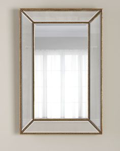 a gold framed mirror hanging on the wall