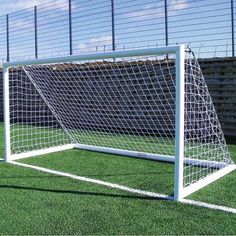 a soccer goal sitting on top of a lush green field