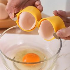 an egg being cracked into two halves in a glass bowl