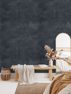 a bedroom with dark blue walls and white linens on the bed, along with a wooden bench