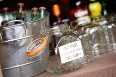 there are many empty glass jars on the table with labels in front of each one