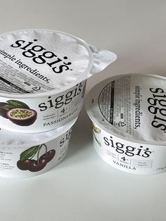 three yogurts are sitting on a white surface