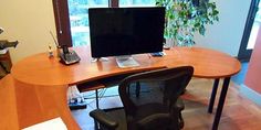 an office desk with two computers on it