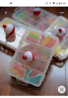 two plastic containers filled with different colored candies on top of a wooden table next to each other