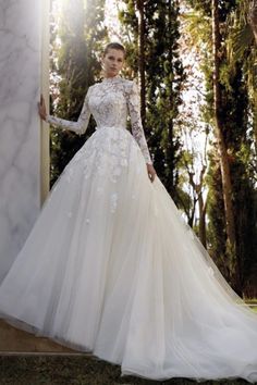 a woman in a white wedding dress standing outside