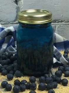 blueberries are scattered around a mason jar