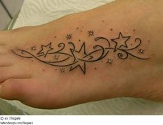 a woman's foot with stars on it and the word love written in cursive writing