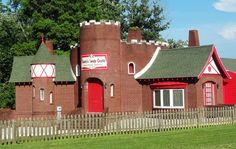 a red brick building with white trim and windows on the front, surrounded by trees