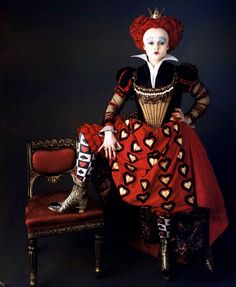 a woman in a red and black dress sitting on a chair