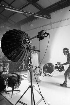 black and white photograph of photographer in front of camera set up with umbrella on tripod