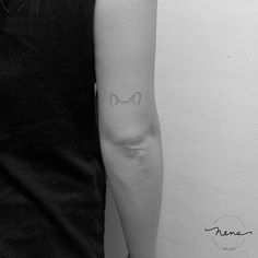 a woman's arm with a cat tattoo on the left side of her arm